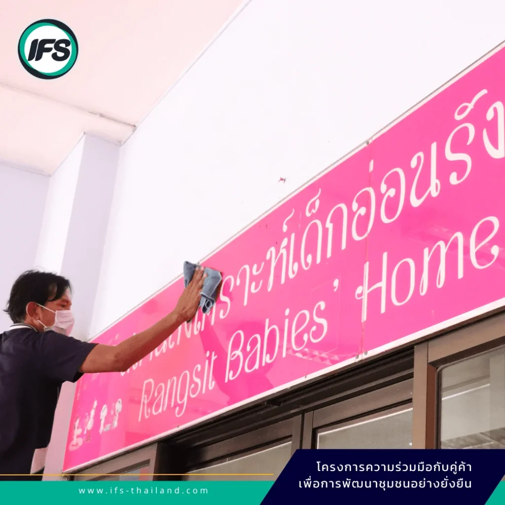 พนักงานบริษัท IFS Facility Services ปฏิบัติงานทำความสะอาดป้ายอาคารในโครงการ Customer & Community Partnership Program เพื่อการพัฒนาชุมชนอย่างยั่งยืน