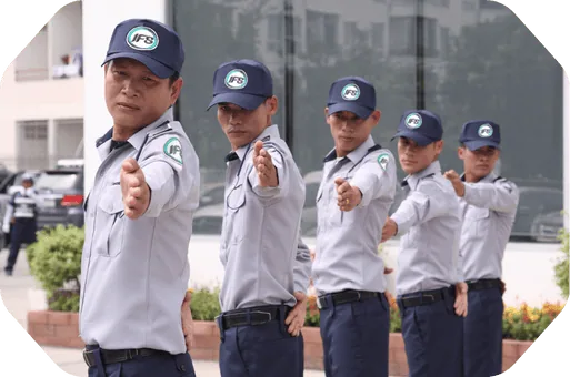 ทีมเจ้าหน้าที่รักษาความปลอดภัย IFS ยืนเรียงแถวในท่าปฏิบัติงานด้านการตรวจตราและควบคุมความปลอดภัยหน้าอาคาร